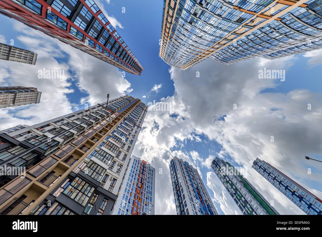 vue d'en bas dans le ciel bleu avec des nuages de grand complexe résidentiel de gratte-ciel moderne Banque D'Images