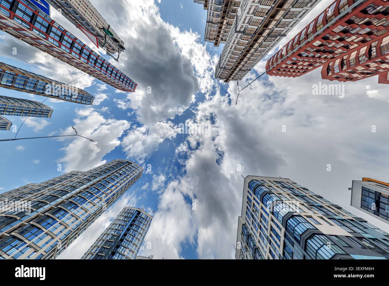 vue d'en bas dans le ciel bleu avec des nuages de grand complexe résidentiel de gratte-ciel moderne Banque D'Images