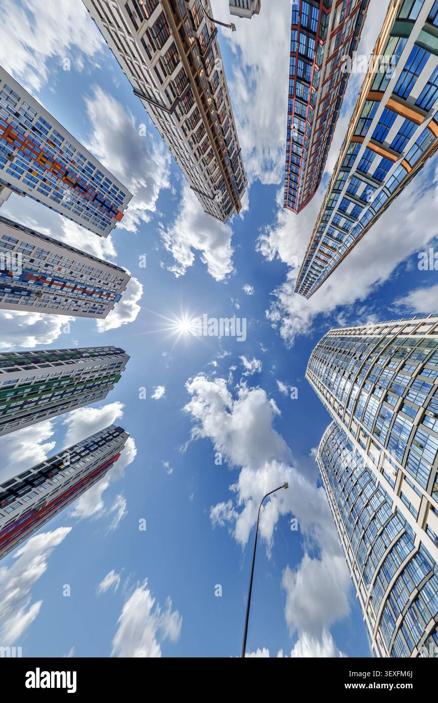 vue d'en bas dans le ciel bleu avec des nuages de grand complexe résidentiel de gratte-ciel moderne Banque D'Images