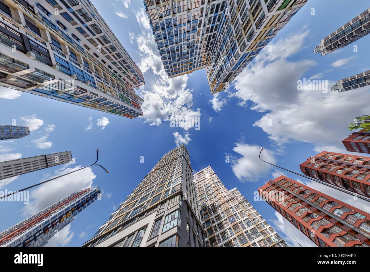 vue d'en bas dans le ciel bleu avec des nuages de grand complexe résidentiel de gratte-ciel moderne Banque D'Images