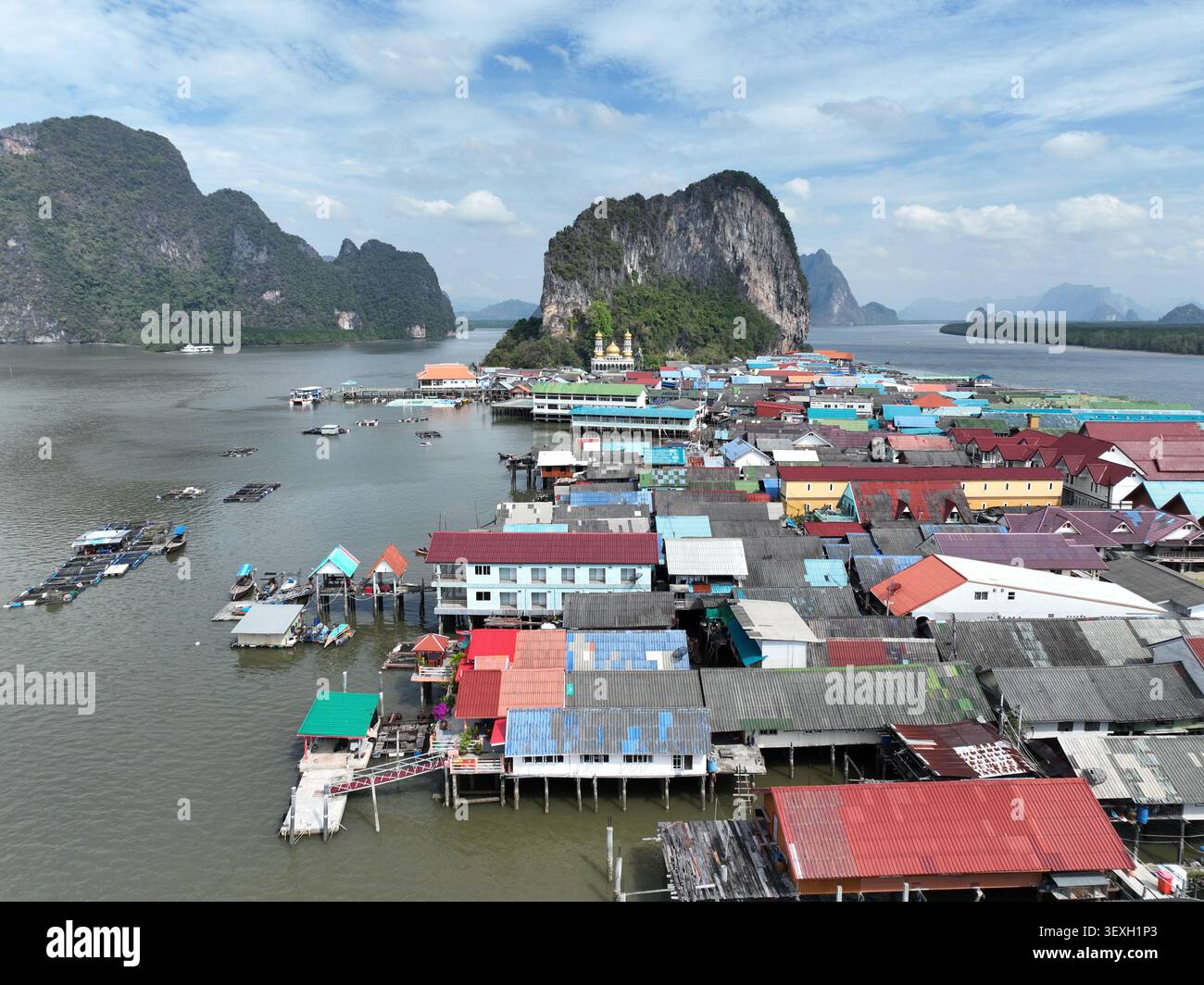 Vue aérienne du village flottant de Koh Panyi avec des maisons colorées sur pilotis et des fermes piscicoles entourées de karsts calcaires dans la mer d'Andaman, Ko Panyi Banque D'Images