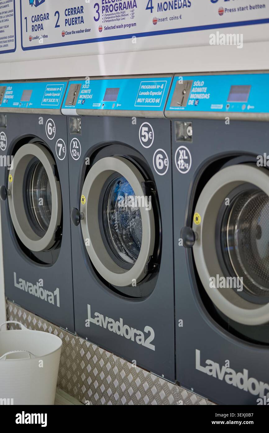 Les vêtements colorés sont séchés dans un sèche-linge dans une laverie automatique. Banque D'Images