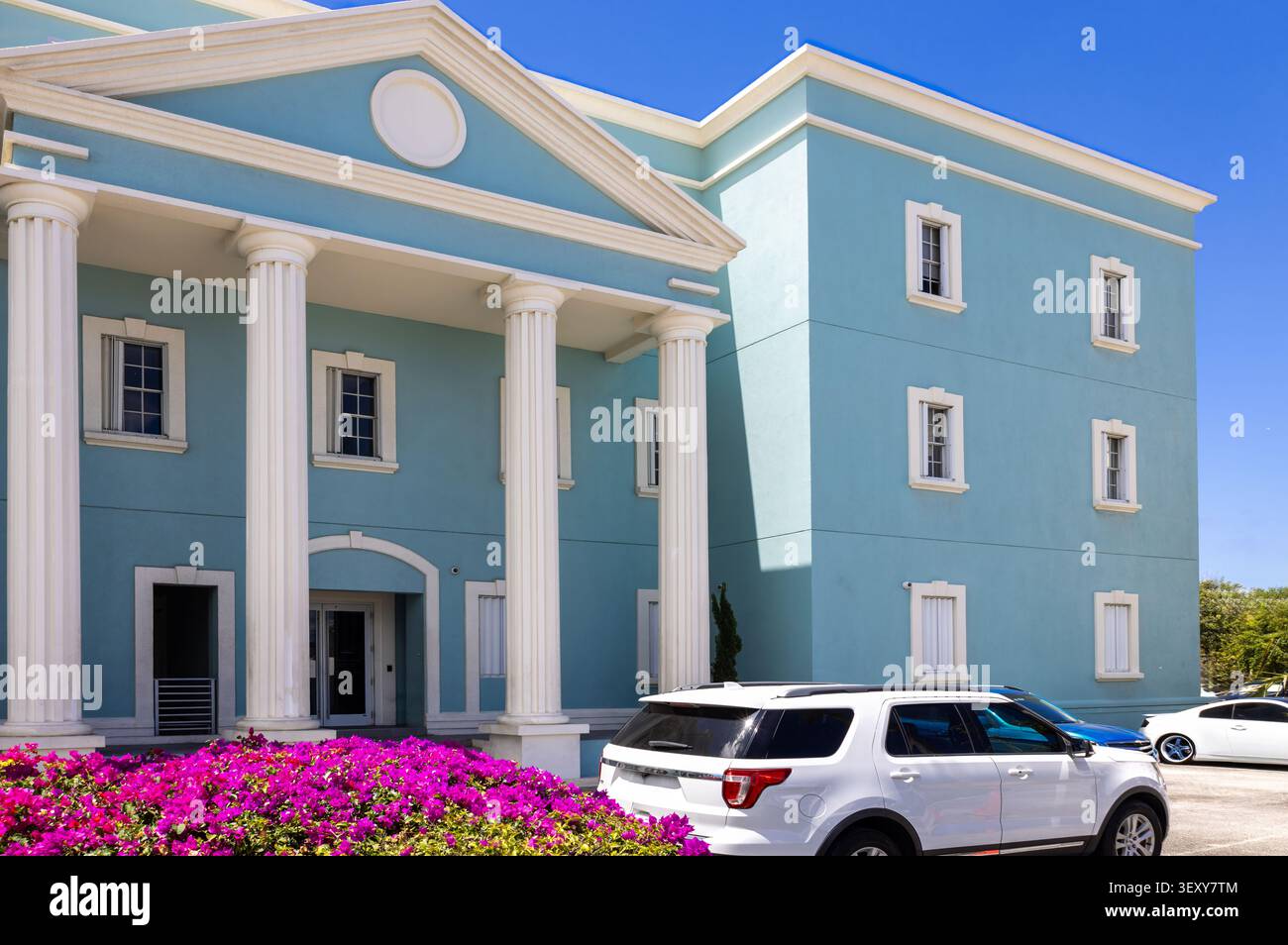 Un bâtiment néoclassique bleu clair avec des colonnes blanches proéminentes et des cadres de fenêtres dans les îles Caïmans historiques de George Town Banque D'Images