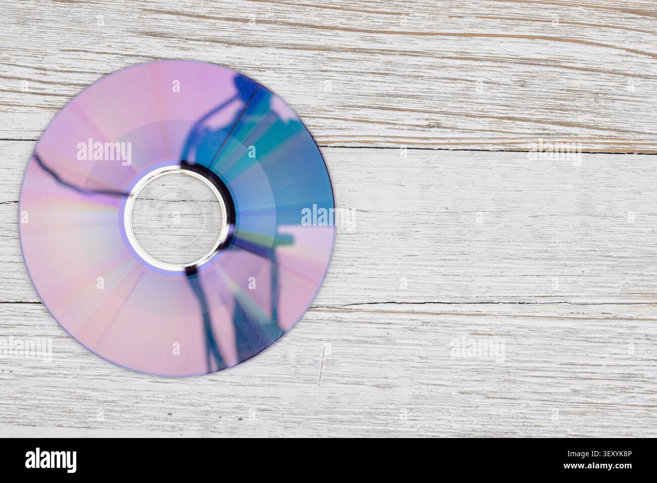 Disque compact brillant sur une surface en bois clair symbolisant le stockage de données, la technologie et les supports numériques, idéal pour la sauvegarde, l'archivage, et technique Banque D'Images