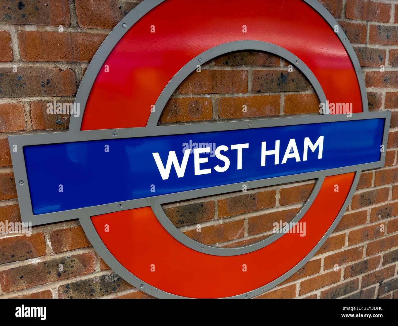 Rondelle de la station de métro West Ham à Londres sur un mur de briques à Newham, dans l'est de Londres, une zone fortement associée au West Ham United FC Banque D'Images