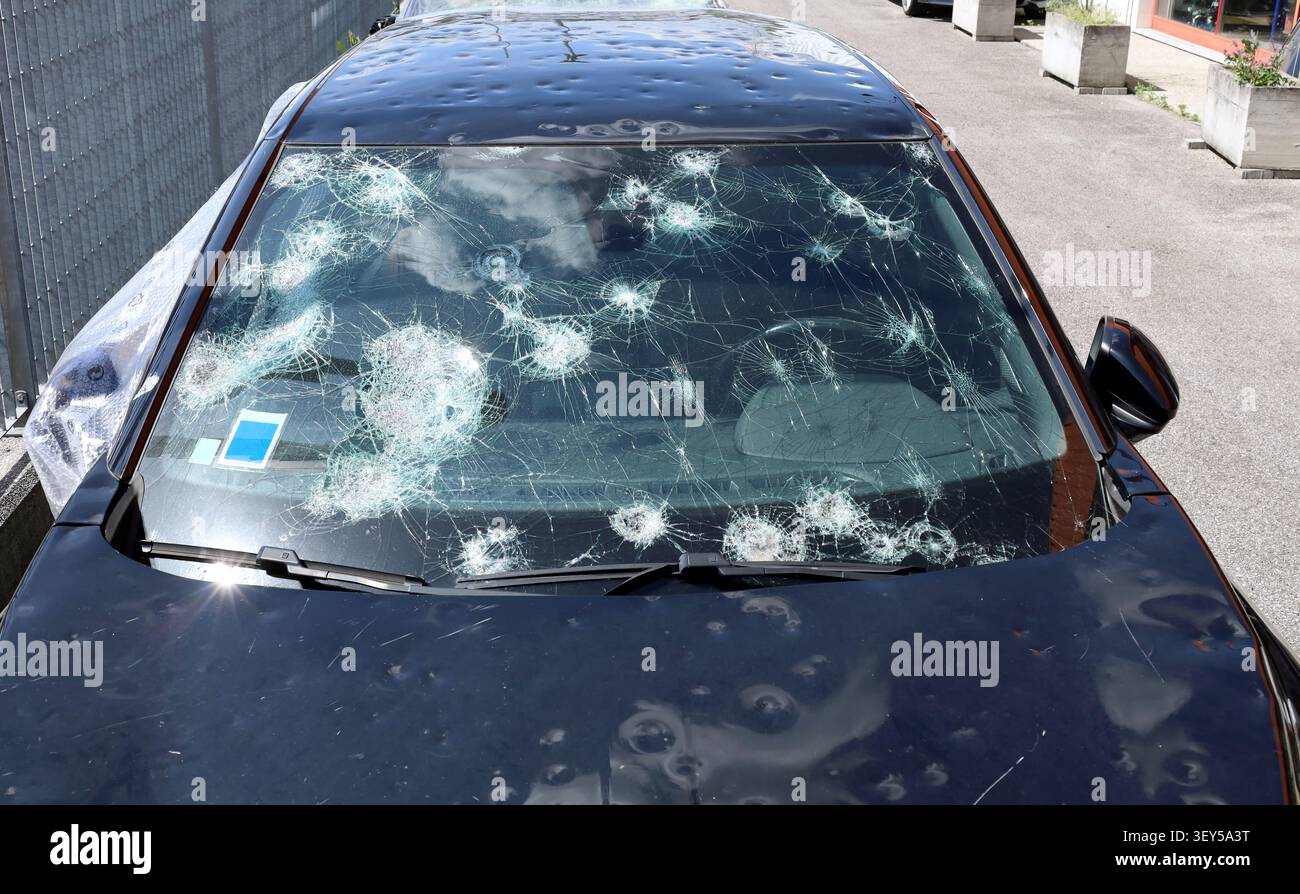 Pare-brise et carrosserie d'une voiture gravement endommagés par une tempête de grêle. Vue avant d'un véhicule méconnaissable. Banque D'Images
