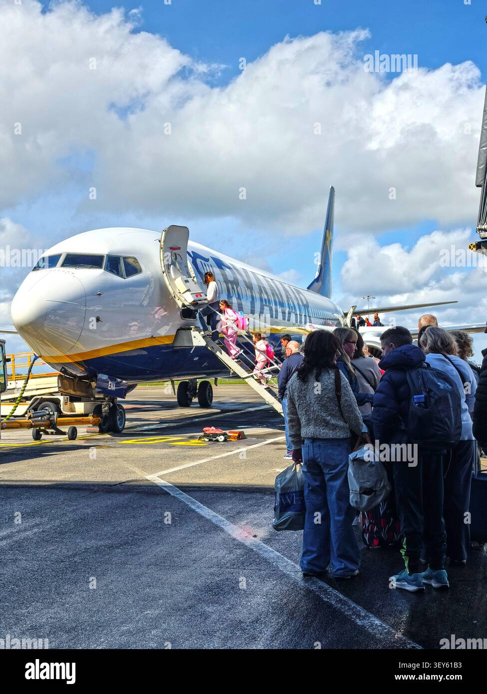 Passagers faisant la queue sur la piste pour embarquer sur un vol Ryanair Banque D'Images