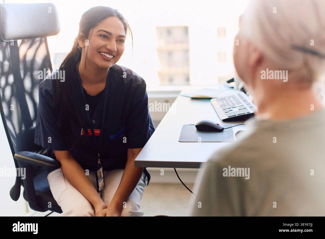 Médecin femme souriante partageant de bonnes nouvelles avec une femme âgée après son bilan Banque D'Images