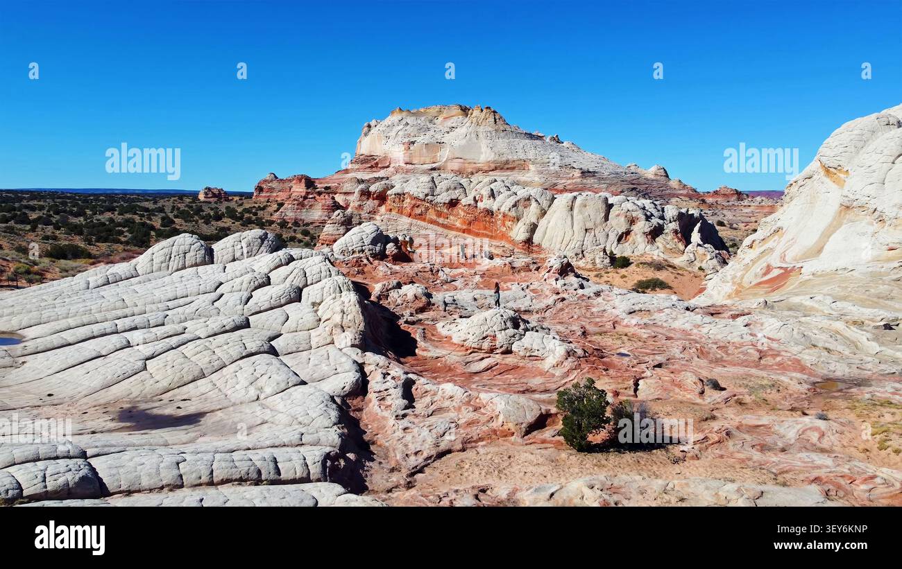 Badlands panoramiques en grès sous Blue Sky. Vue panoramique des formations de grès blanc et rouge avec des crêtes en couches, terrain désertique érodé, clairsemé Banque D'Images