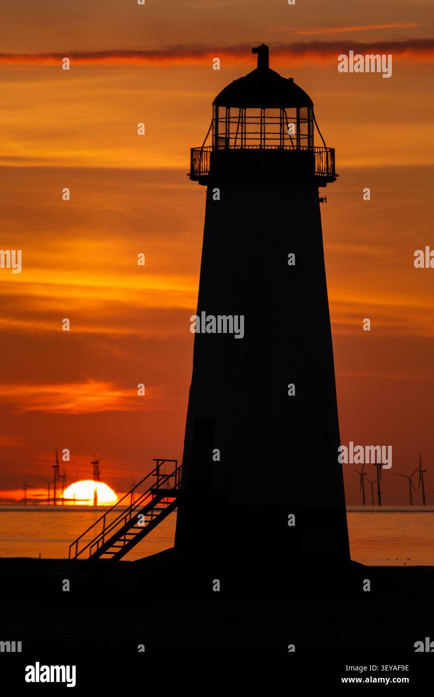Plan vertical spectaculaire du phare de la pointe d'Ayr sur un ciel de coucher de soleil rouge profond et or brillant, Talacre Beach Banque D'Images
