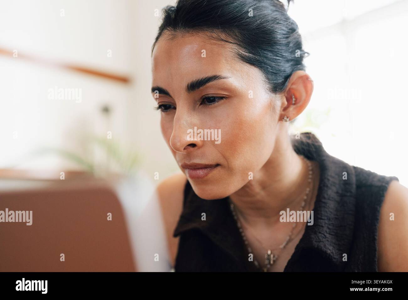 Gros plan d'une femme d'affaires concentrée regardant l'écran de son ordinateur portable tout en travaillant dans un espace de coworking Banque D'Images