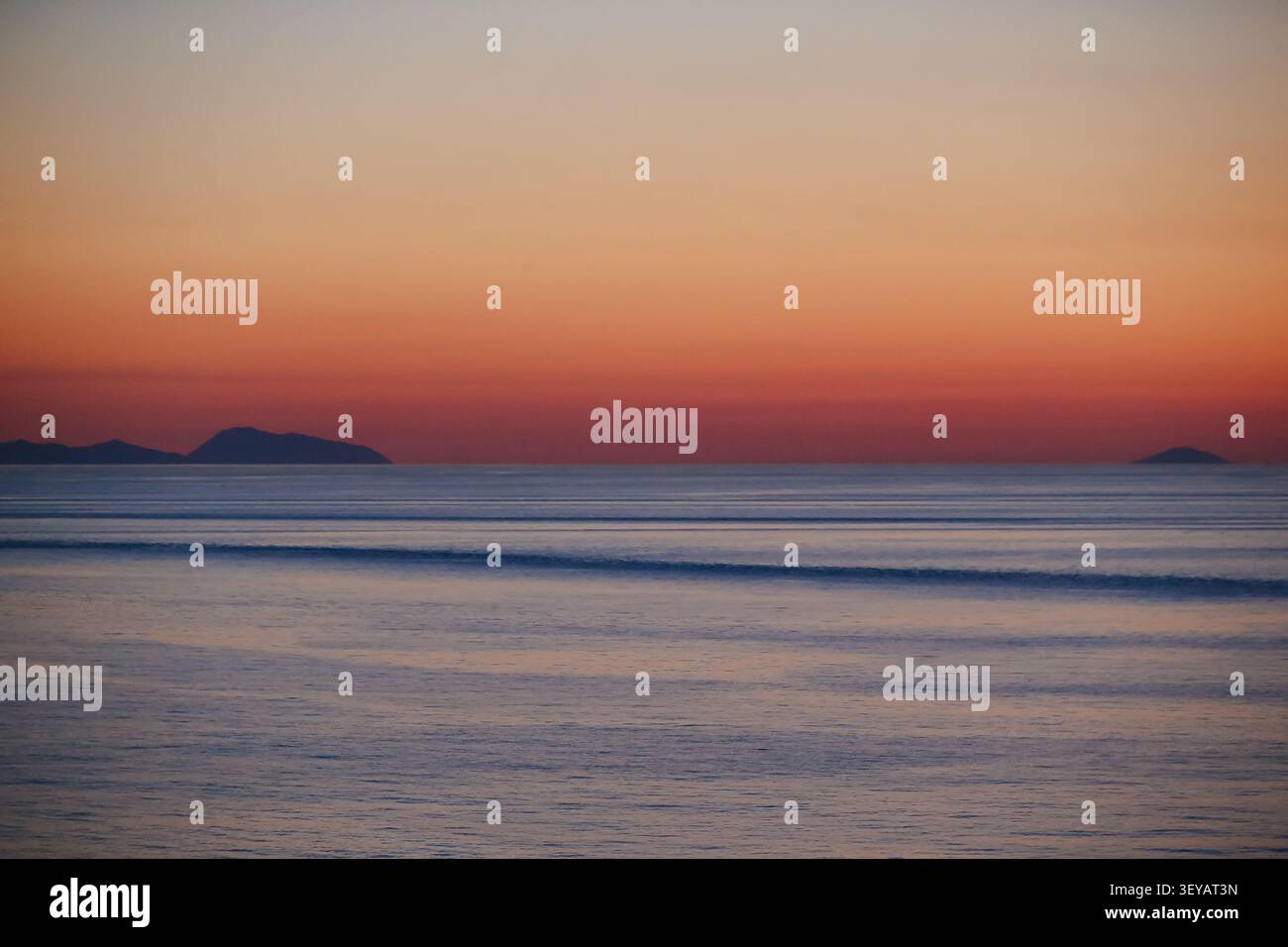 Coucher de soleil sur le golfe de Naples avec des eaux calmes et des îles lointaines sur la mer Tyrrhénienne, Italie. Banque D'Images