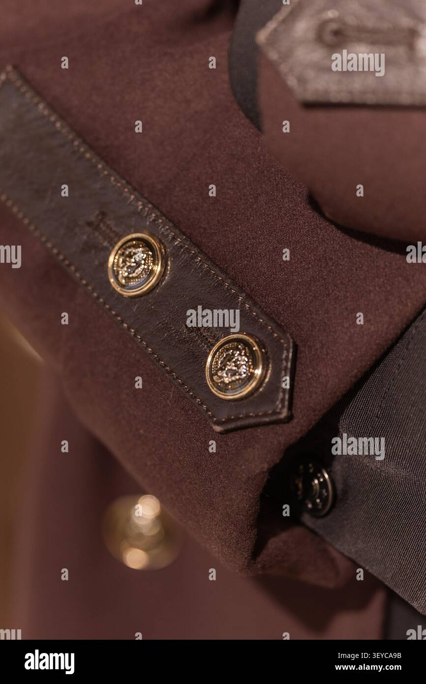 Détail de manche d'un manteau en laine marron de luxe avec boutons décoratifs en lumière chaude naturelle à l'extérieur Banque D'Images