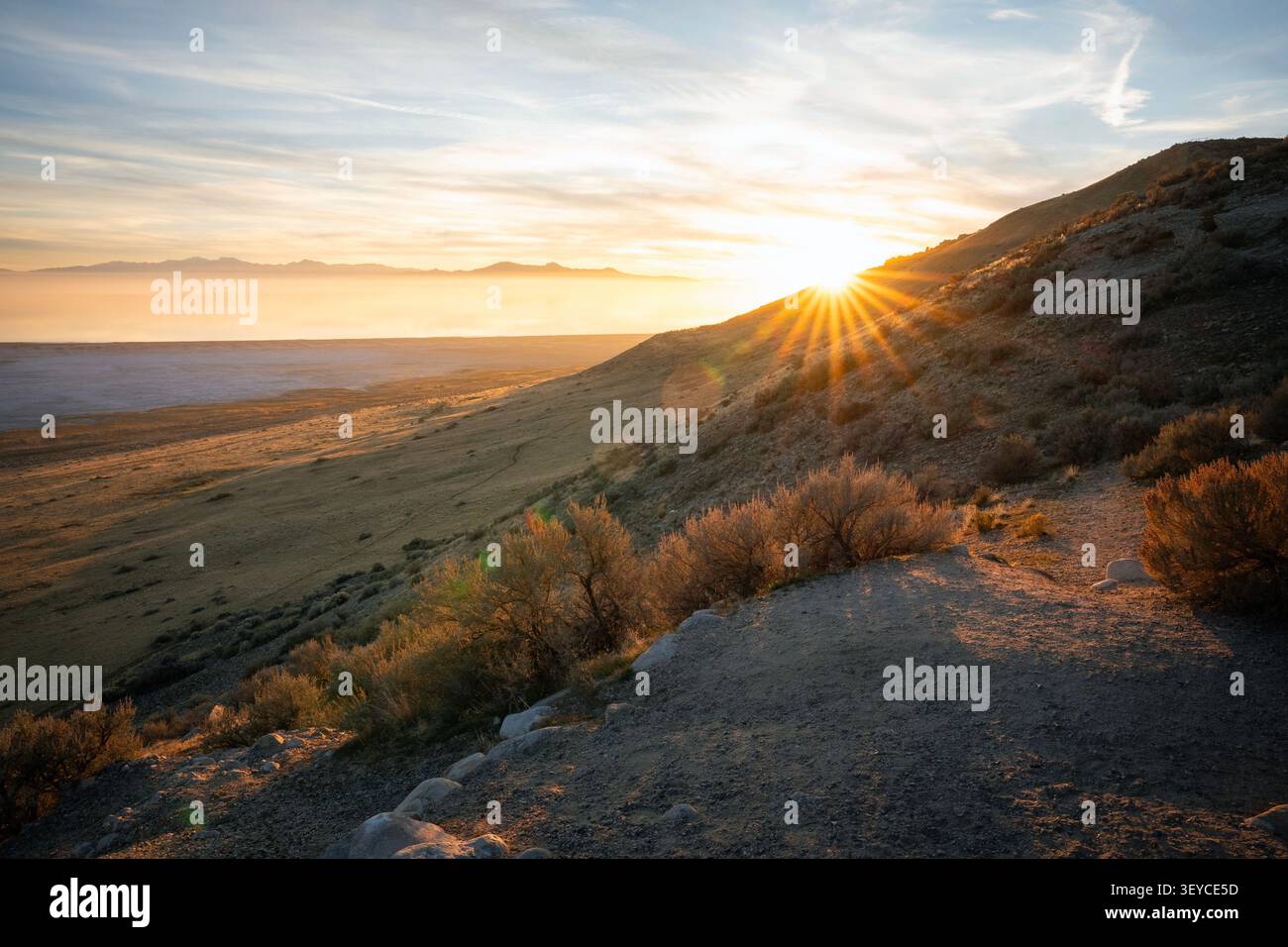 Bel effet de soleil avec des rayons de soleil aigus se brisant sur une pente rocheuse à Antelope Island, Utah. Banque D'Images
