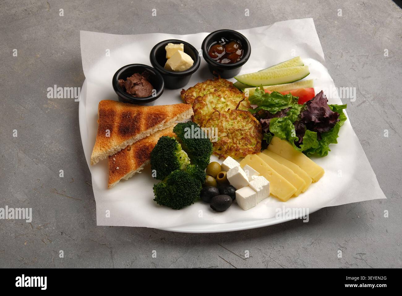 Assiette de hors-d'œuvre végétarienne assortie avec pain grillé, légumes, fromages et trempettes Banque D'Images