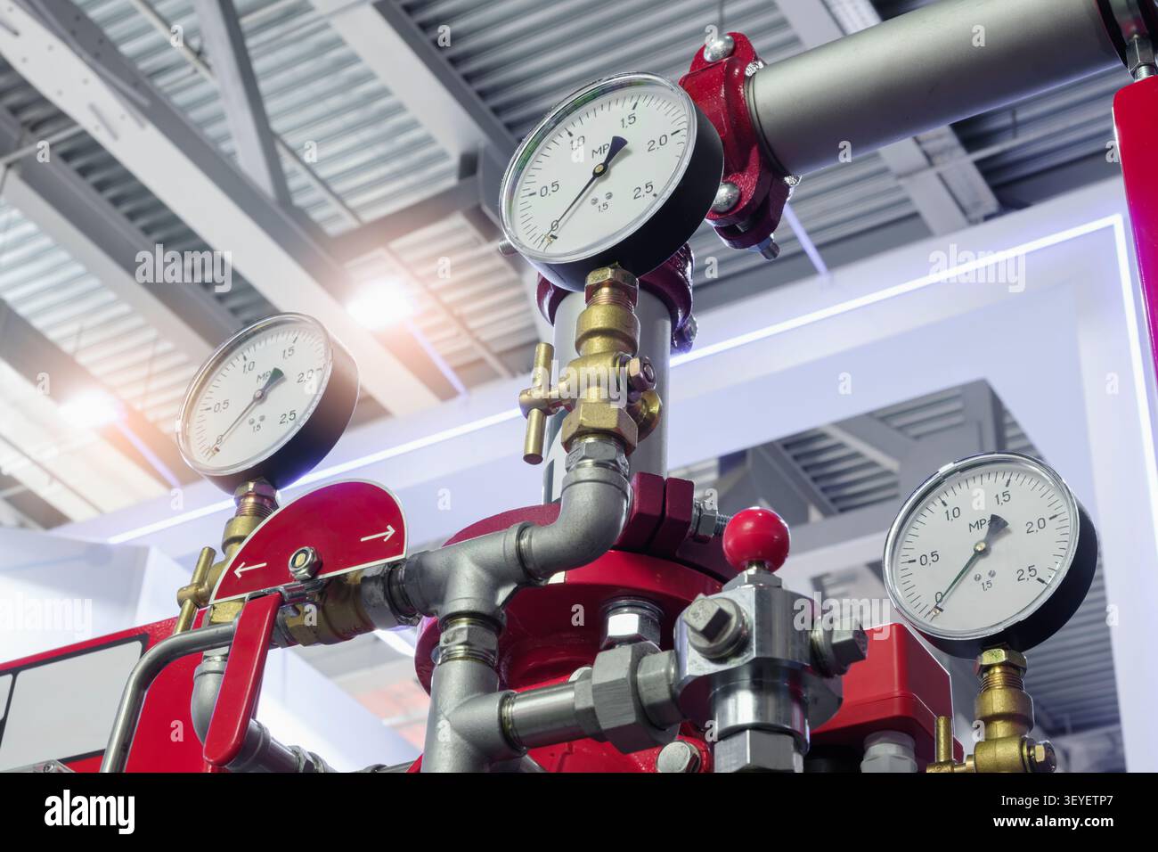Le manomètre rond indique la mesure de la pression du fluide. Les tuyaux métalliques se raccordent à la jauge avec des raccords en laiton. fond de technologie industrielle technologique Banque D'Images