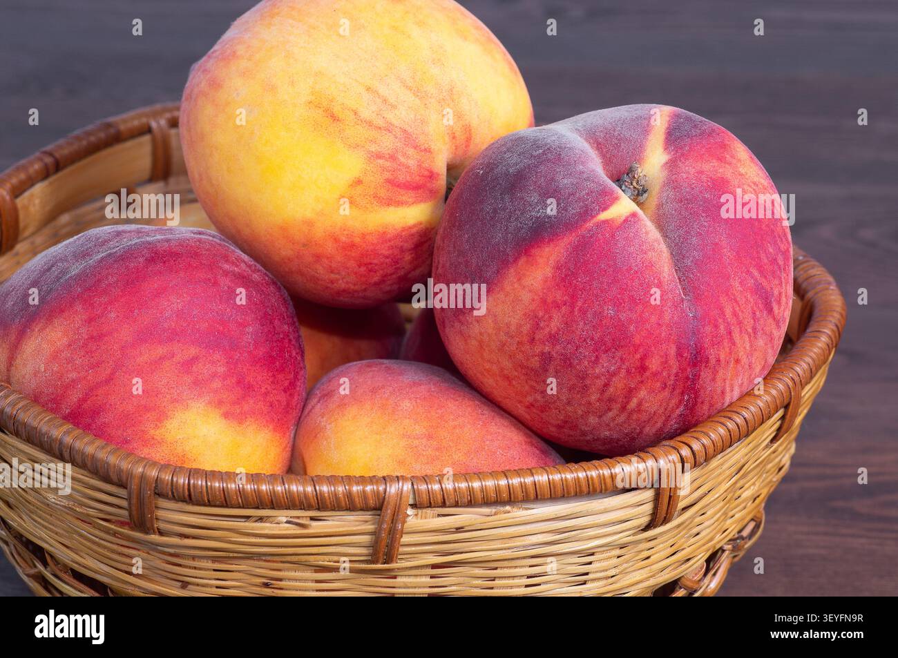 Pêches mûres dans un panier en osier. Banque D'Images