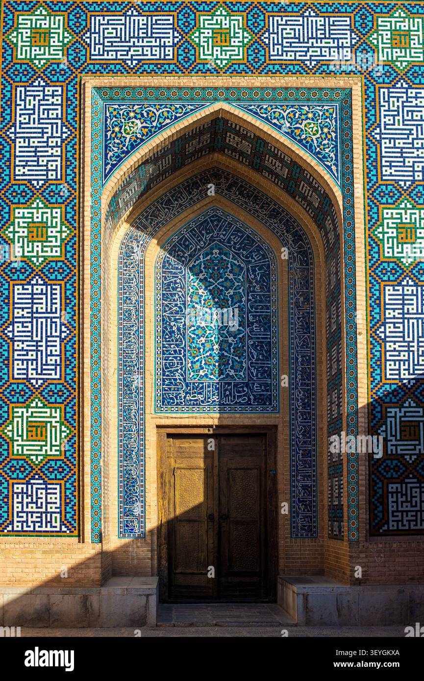 Une ancienne porte en bois sertie dans un superbe portail voûté, finement décorée de mosaïques géométriques complexes et d'inscriptions calligraphiques islamiques en Sha Banque D'Images