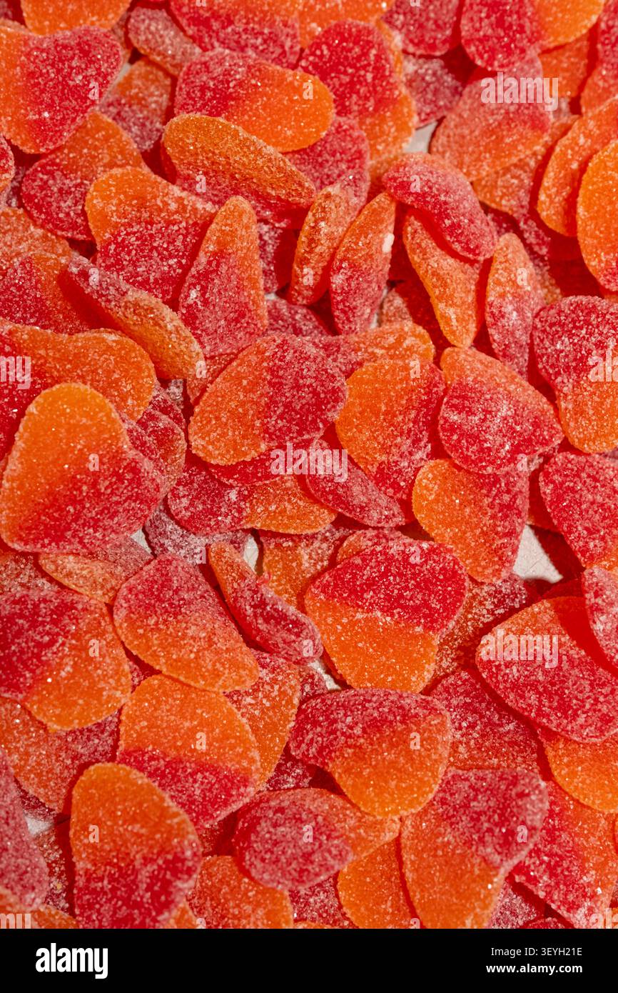De nombreux bonbons colorés sont placés ensemble sur une surface plane. Banque D'Images