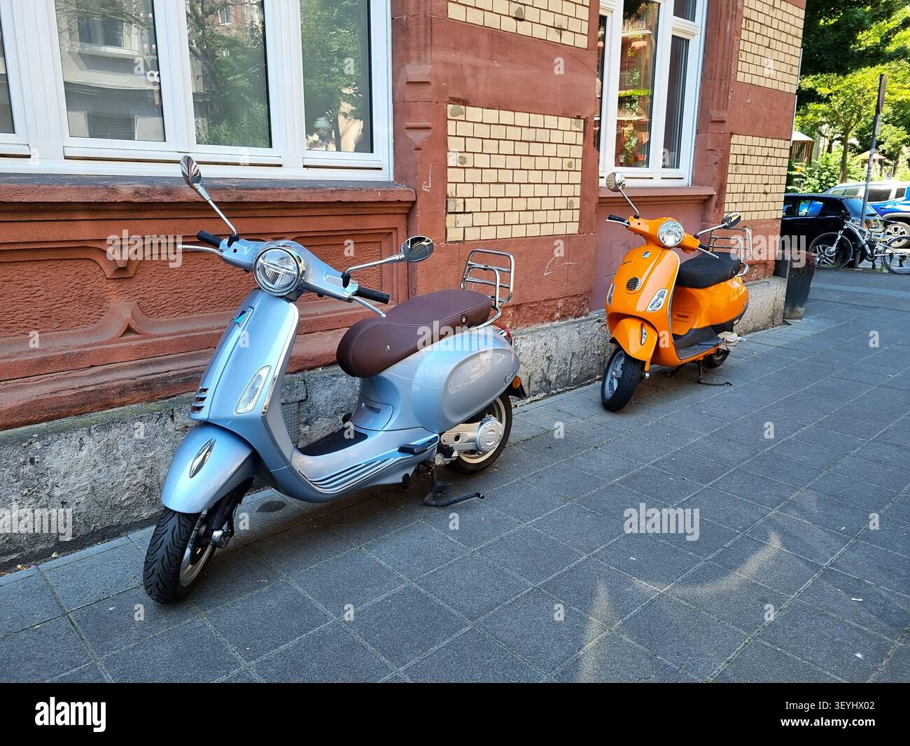 Mainz, rhénanie-palatinat, Allemagne - 19 juin 2026 : deux scooters Vespa stationnés le long d'un trottoir devant un bâtiment résidentiel historique Banque D'Images