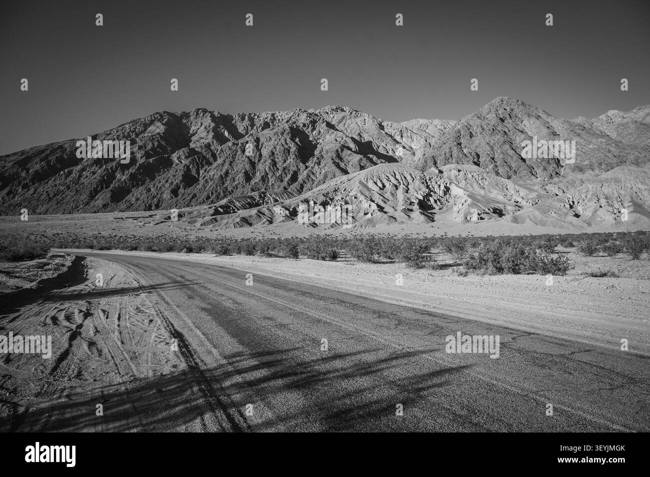Montagnes le long du bassin de Badwater dans le parc national de la Vallée de la mort au coucher du soleil. Californie, États-Unis. Image en noir et blanc. Banque D'Images