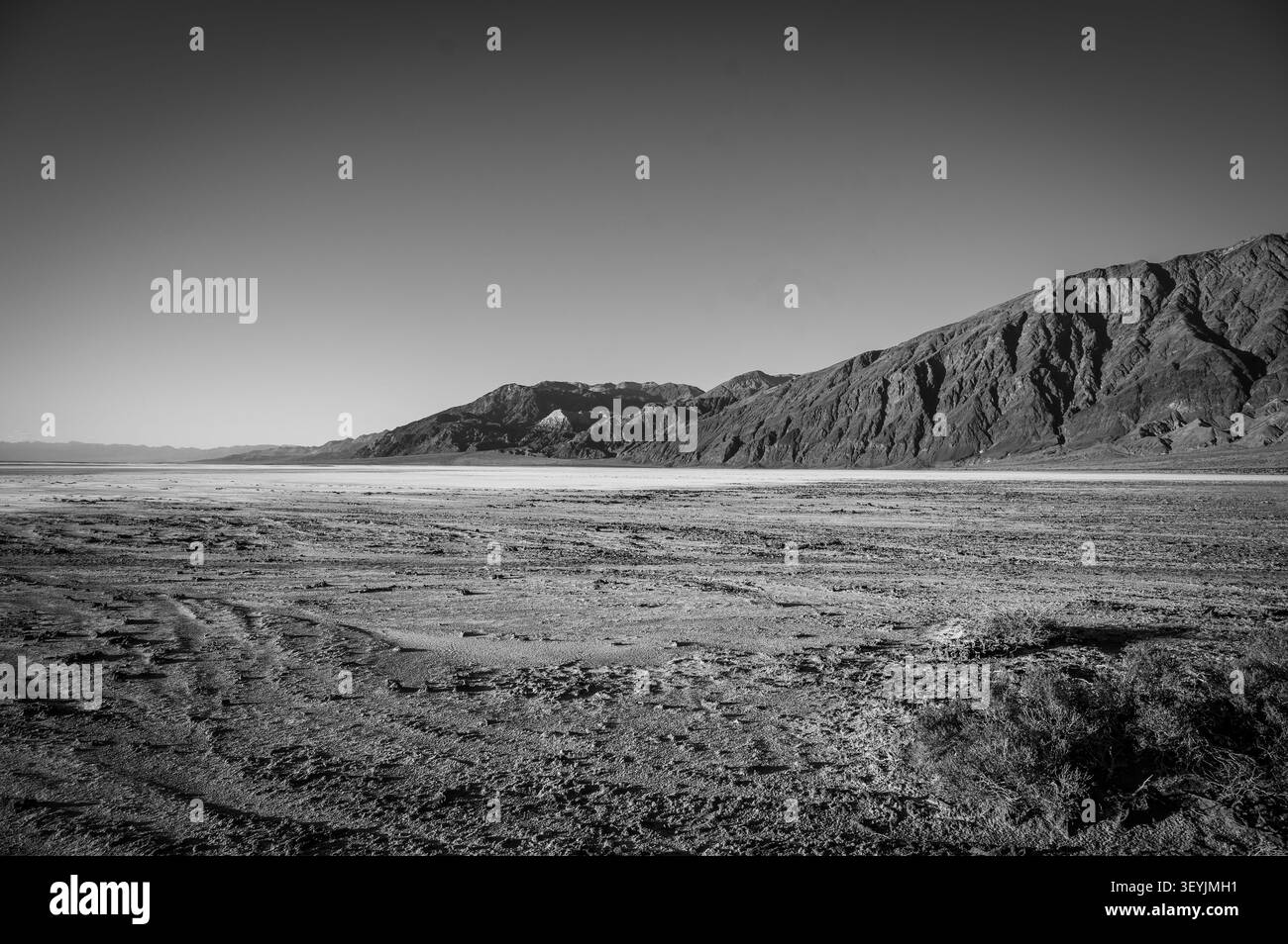 Montagnes le long du bassin de Badwater dans le parc national de la Vallée de la mort au coucher du soleil. Californie, États-Unis. Image en noir et blanc. Banque D'Images