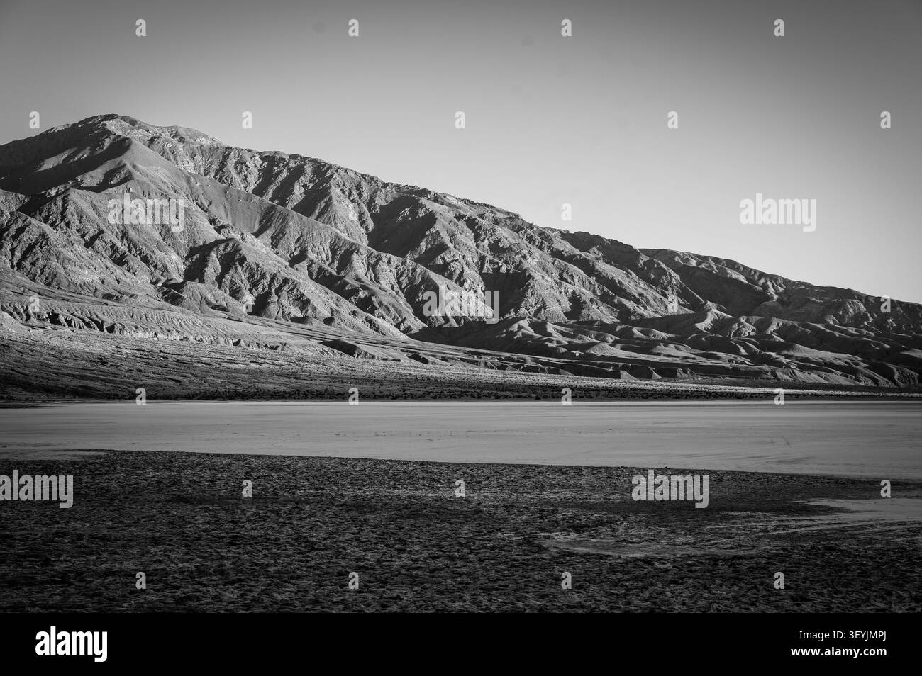 Montagnes le long du bassin de Badwater dans le parc national de la Vallée de la mort au coucher du soleil. Californie, États-Unis. Image en noir et blanc. Banque D'Images