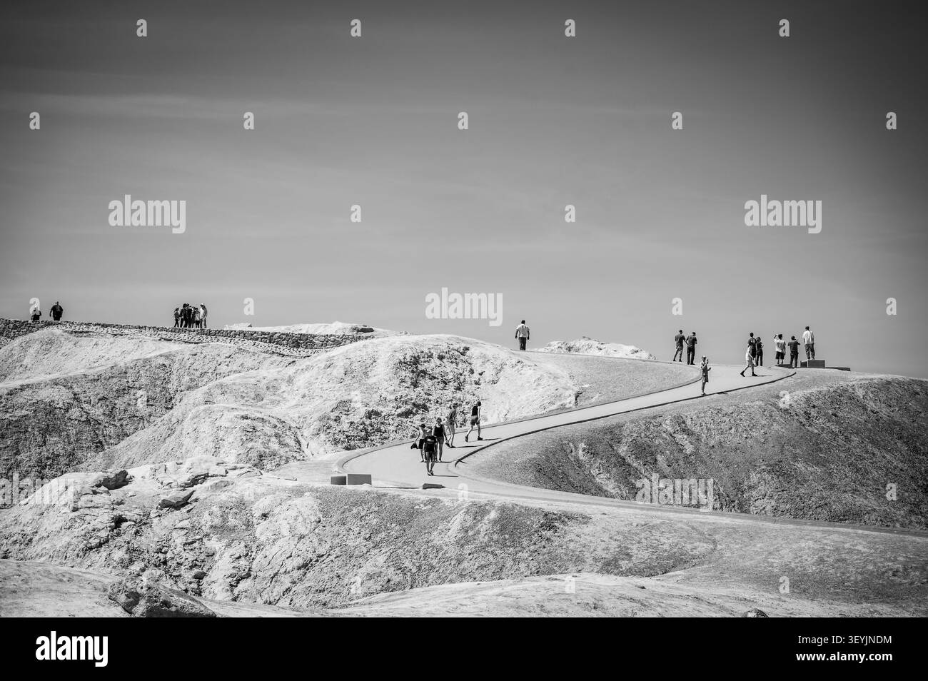 Touristes à Zabriskie point le long de l'autoroute 191. Parc national de la Vallée de la mort, Californie, États-Unis. Image en noir et blanc. Banque D'Images