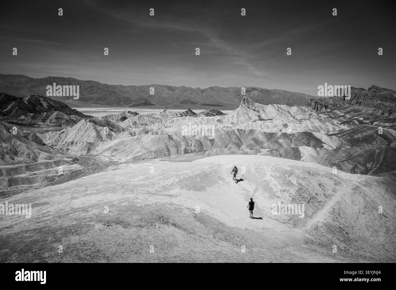 Deux randonneurs dans le désert à Zabriskie point le long de la route 191. Parc national de la Vallée de la mort, Californie, États-Unis. Image en noir et blanc. Banque D'Images