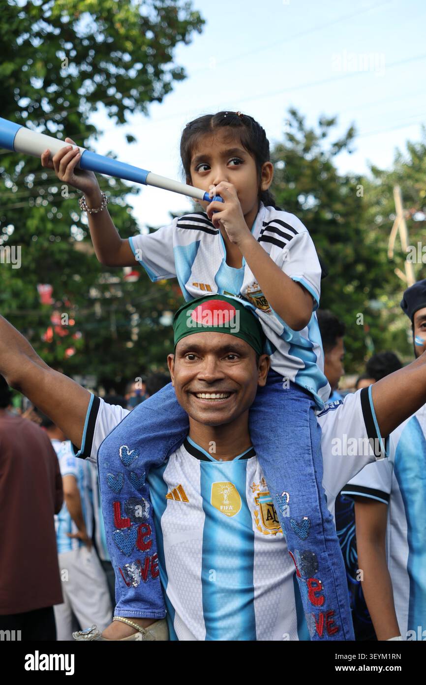 Père portant sa fille sur les épaules lors de la célébration de la projection publique des fans de football argentin à Dhaka, au Bangladesh. Banque D'Images