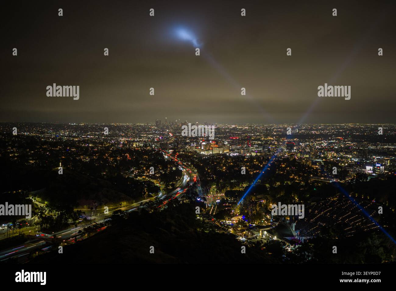 Vue aérienne nocturne de Los Angeles avec des routes lumineuses et Hollywood Bowl la nuit. Quartier hollywoodien dense, gratte-ciel lointain, sombre Banque D'Images