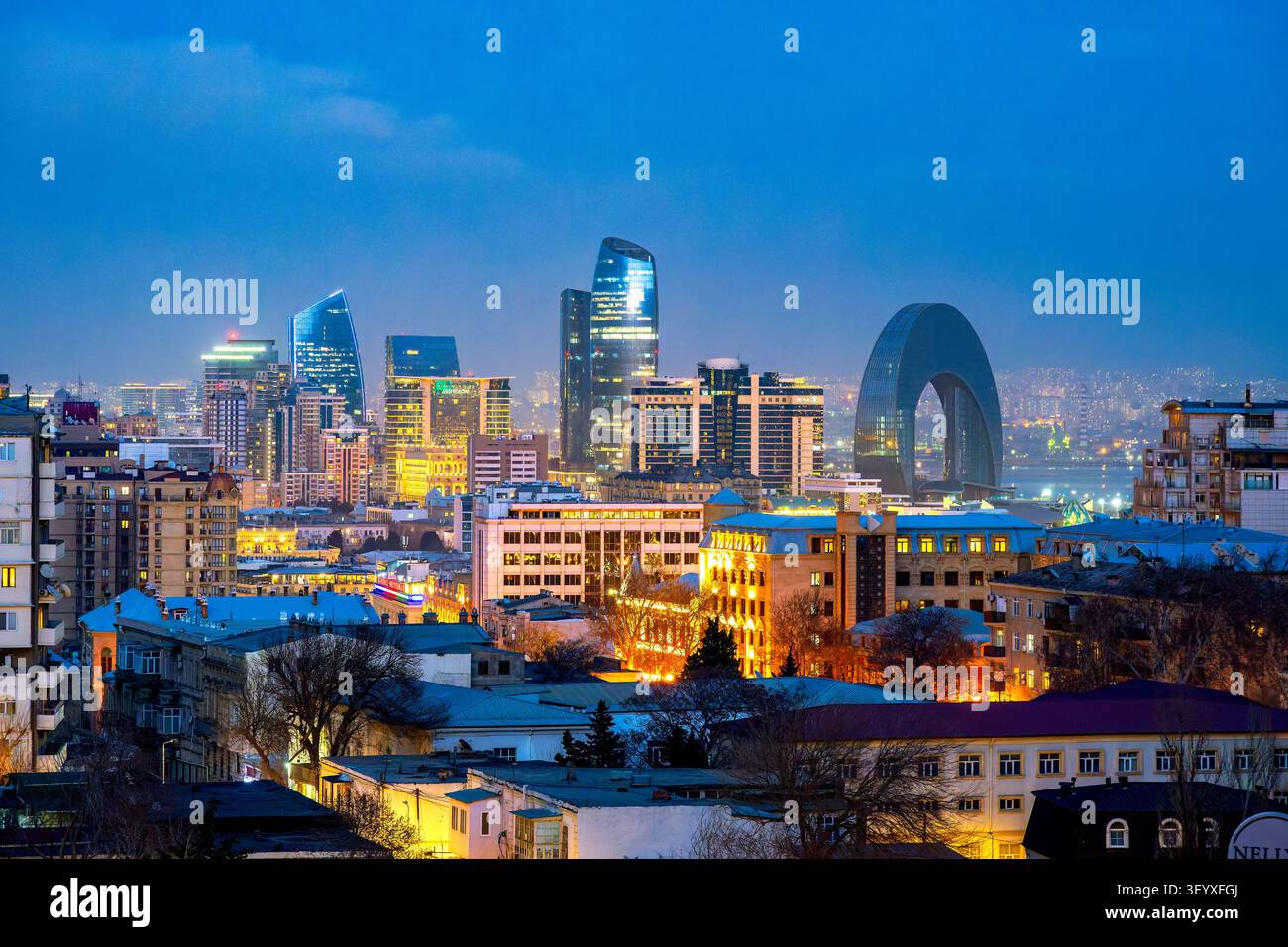 Vue panoramique sur la ville de Bakou à l'heure bleue avec Port Baku Towers et Crescent Hotel au-dessus des quartiers résidentiels historiques. Bakou, Azerbaïdjan. Banque D'Images
