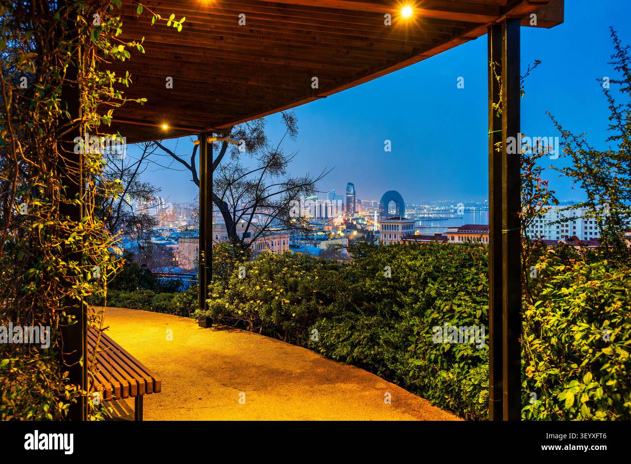 Pergola illuminée dans le parc Chambarakand encadrant une vue panoramique nocturne sur Bakou horizon avec Port Baku Tower et Crescent Hotel. Bakou, Azerbaïdjan. Banque D'Images
