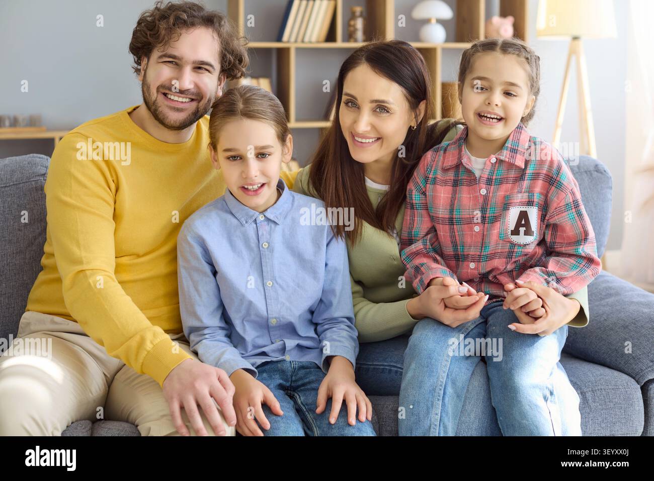 Heureux portrait de famille de parents avec deux filles souriant ensemble à la maison Banque D'Images