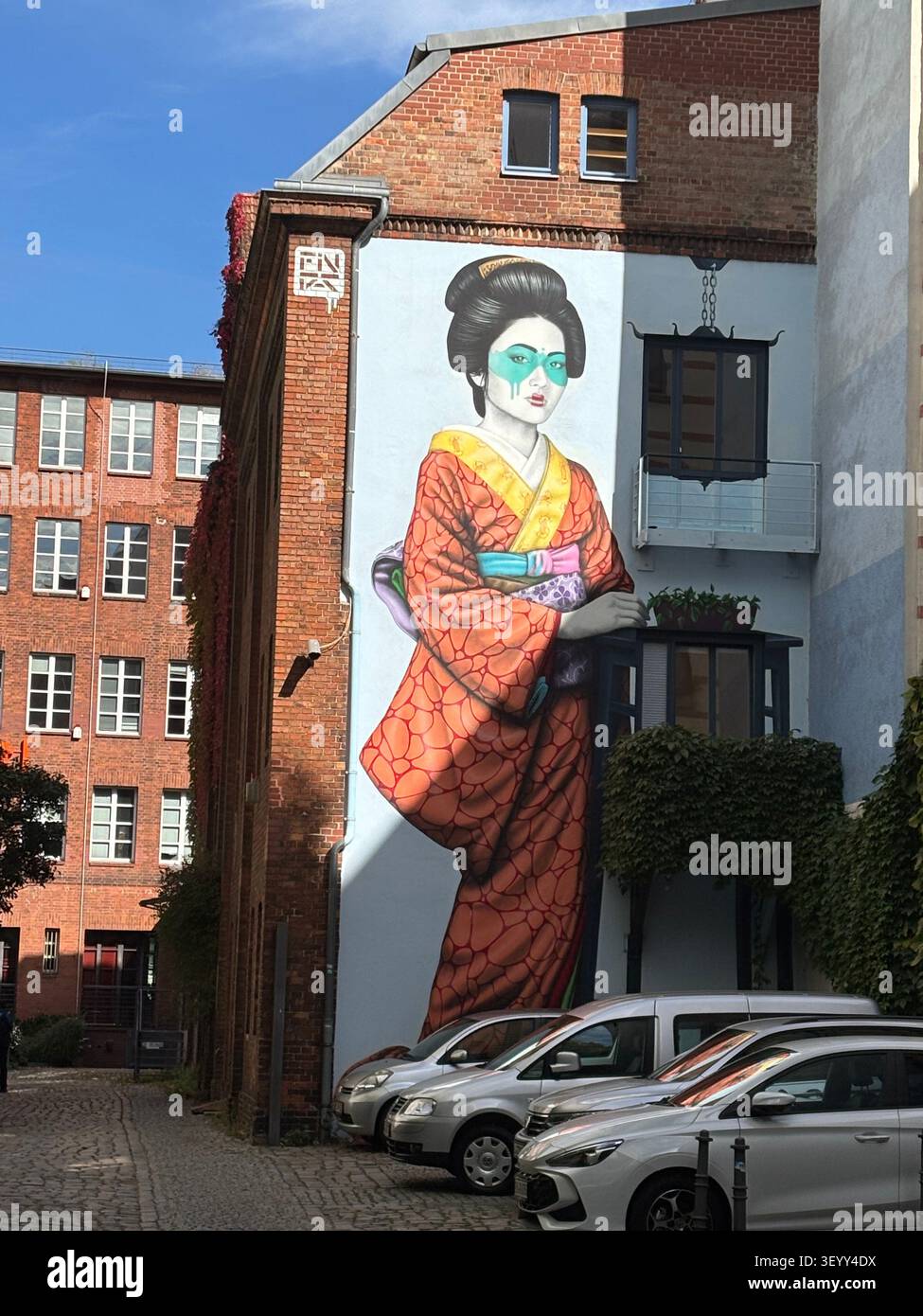 Une grande fresque d'art de rue colorée représentant une femme japonaise en kimono peinte sur un mur en briques, Berlin, Allemagne - Image de stock capturée avec un smartphone