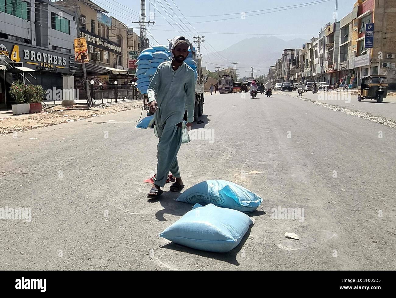 QUETTA, PAKISTAN - 05 juillet 2026 : dimanche, un sac de farine est tombé d'un camion sur Samangali Road à Quetta, au Pakistan, ce qui a perturbé la circulation et soulevé des problèmes de sécurité. L'incident, capturé par Sami Khan de PPI images, s'est produit dans une zone commerciale animée, mettant en évidence les défis liés au transport de matériaux en vrac dans des environnements urbains fréquentés. Cet événement souligne la nécessité de règles de sécurité plus strictes pour prévenir de tels événements, qui peuvent perturber la circulation et présenter des dangers pour les piétons et les conducteurs. Les entreprises locales, y compris les restaurants et les magasins, ont été témoins de la perturbation. (Sami Khan Banque D'Images