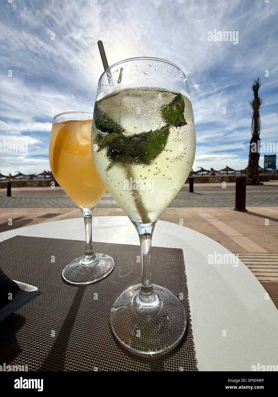 Deux cocktails rafraîchissants sur une table en plein air près d'une promenade de la plage par une journée ensoleillée - Image de stock capturée avec un smartphone