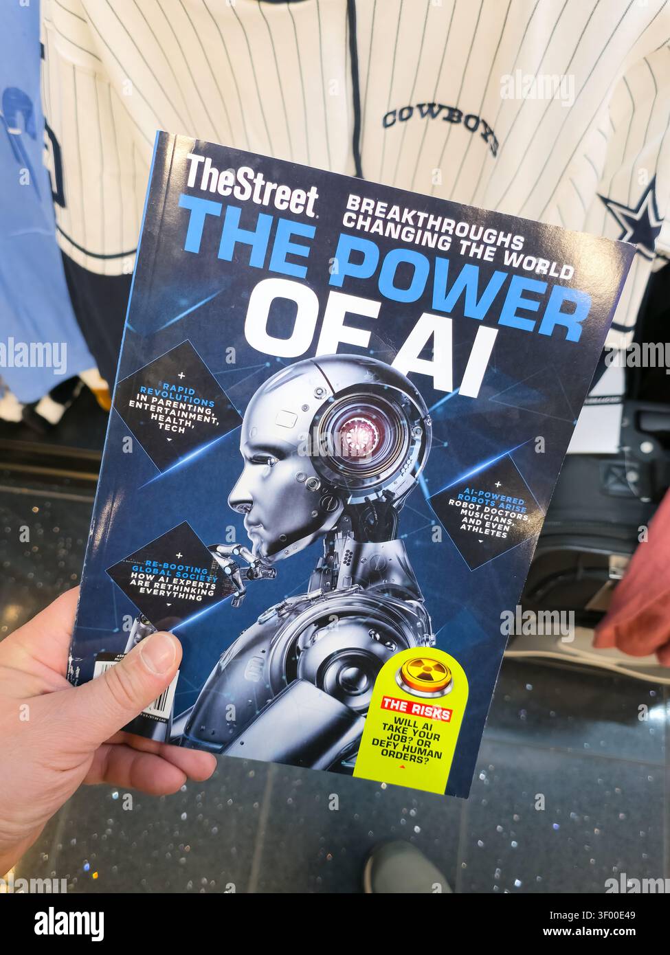CHICAGO, il, États-Unis - 20 JANVIER 2026 : une personne tient le magazine 'TheStreet : The Power of ai' sur fond de maillot Cowboys. TheStreet est un leadi Banque D'Images