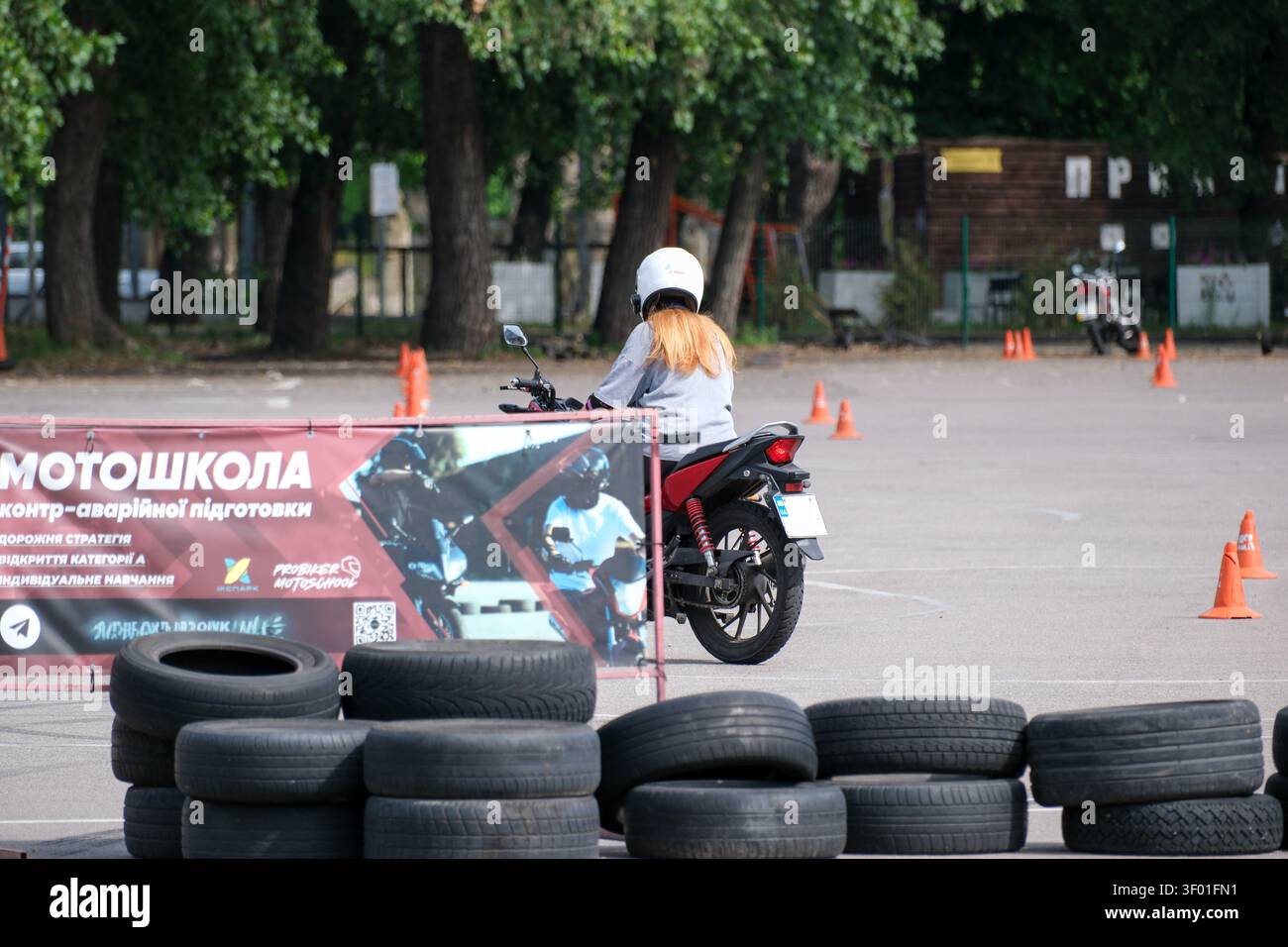 KIEV, UKRAINE, 5 JUILLET 2026, étudiant conduisant une moto pendant une leçon pratique sur un terrain d'entraînement de moto avec des cônes de circulation et des obstacles de sécurité Banque D'Images