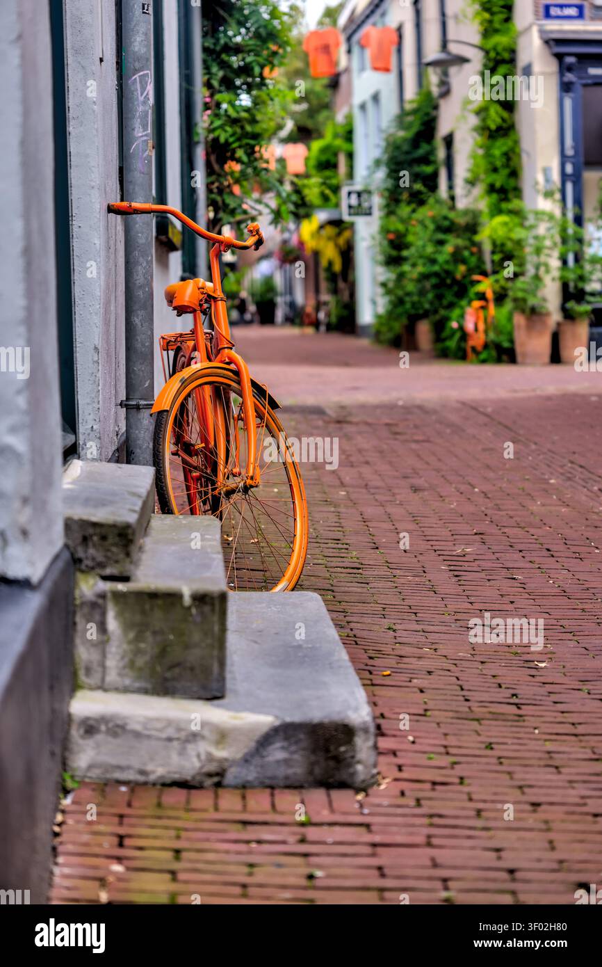 Vélo orange garé sur la Bentinckstraat dans le quartier des 7straaten d'Arnhem, Pays-Bas. Banque D'Images