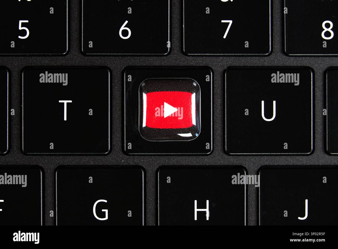 DALLAS, TX, États-Unis - 16 FÉVRIER 2024 : vue rapprochée d'un clavier noir où la touche traditionnelle de la lettre G a été remplacée par un bou rouge de lecture YouTube Banque D'Images