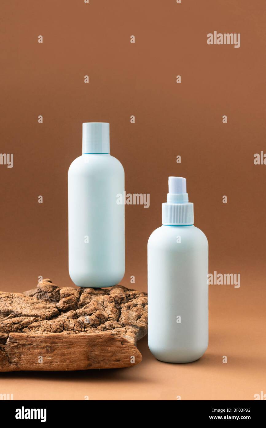 Bouteilles cosmétiques bleu clair minimalistes sur une surface en bois naturel sur fond brun. Soin spa bio, concept éco-beauté. Banque D'Images