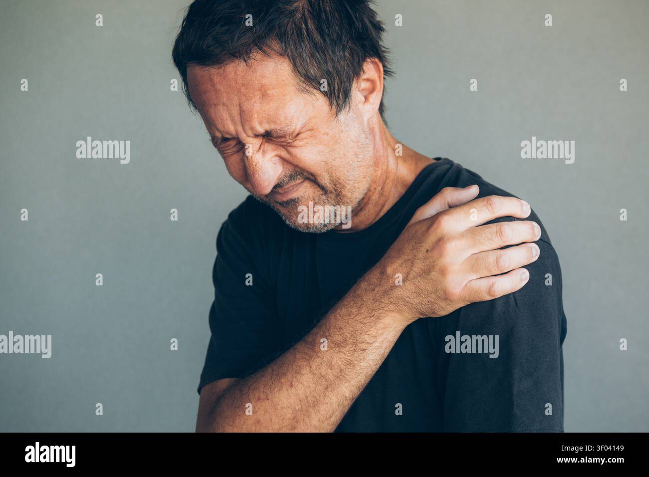 L'homme saisit son épaule dans la douleur visible, la concentration sélective Banque D'Images