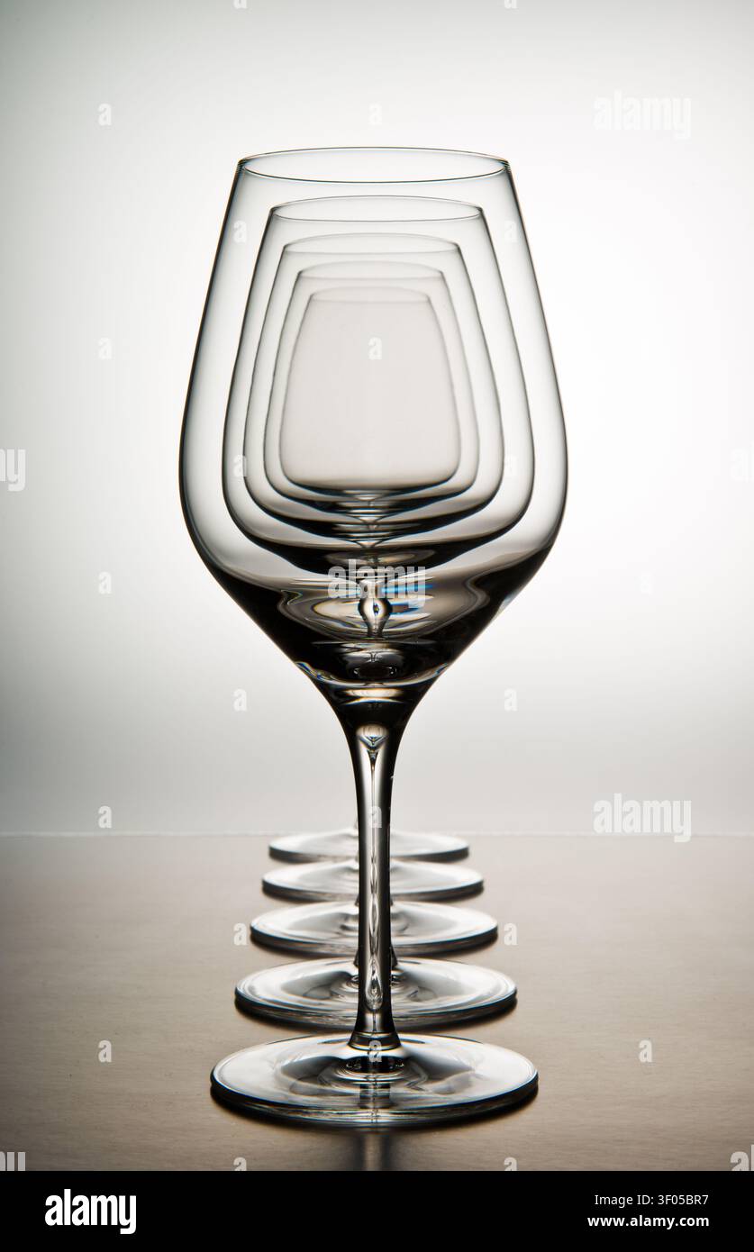 Rangée de verres à vin vides reflétant la création de profondeur et une illusion d'optique Banque D'Images