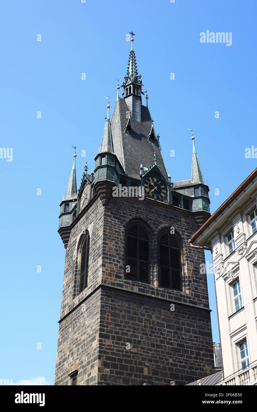 Vue détaillée de la tour de l'hôtel de ville médiéval de Prague présentant une architecture gothique, un cadran d'horloge et des flèches décoratives sous un soleil d'été éclatant Banque D'Images