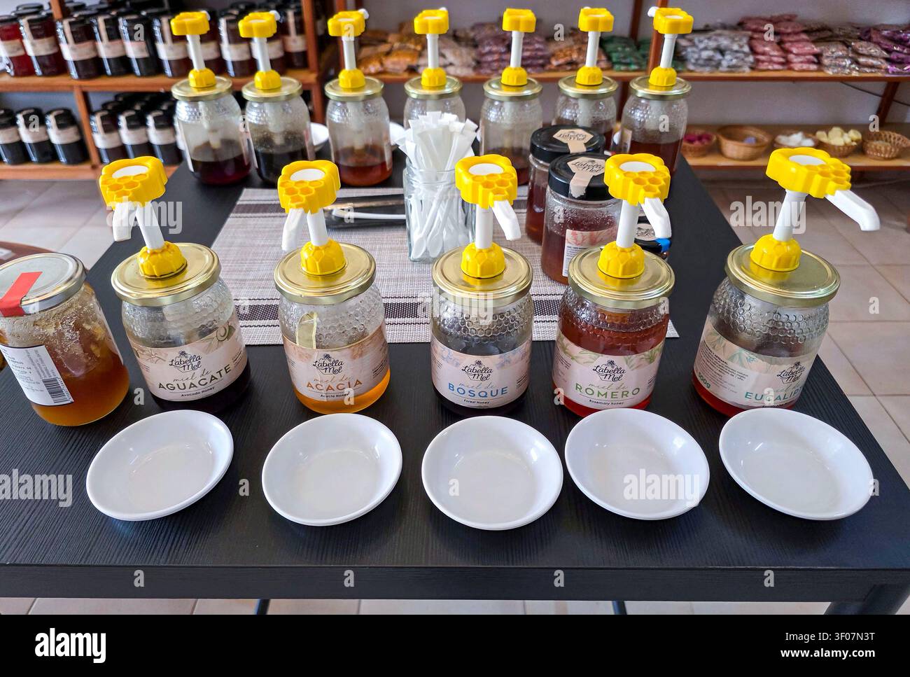 XALO, ESPAGNE – 20 JUIN 2026. Les visiteurs d'un poste de dégustation de miel à Xalo, Alicante, goûtent différents types de miel biologique de Labella Mel. Pots Banque D'Images