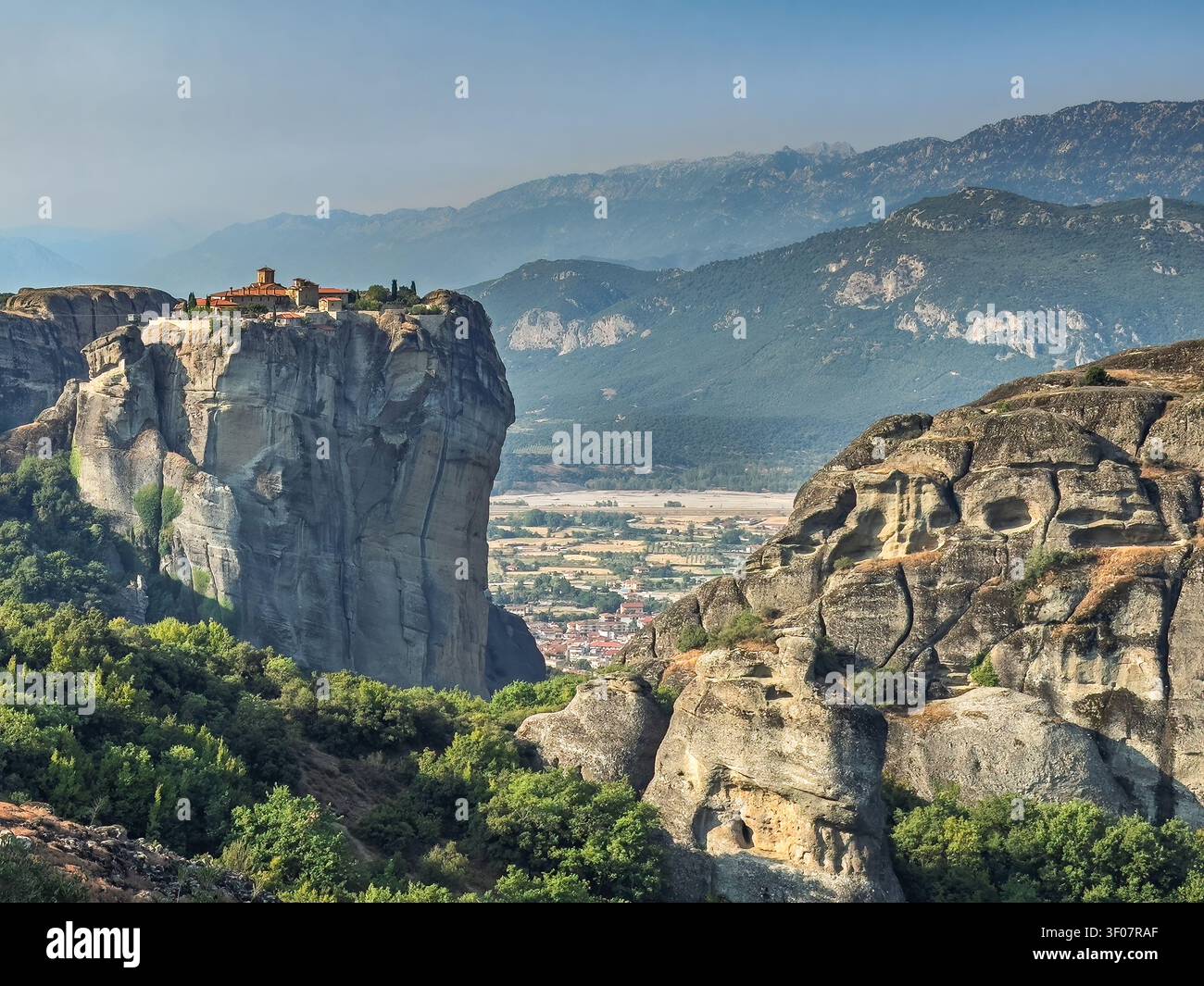 Kalambaka, Grèce - 24 juillet 2024 : groupe de monastères de Météora. Monastère de Saint-Étienne sur son plateau rocheux, avec, bien en contrebas, la ville de Kalambaka Banque D'Images