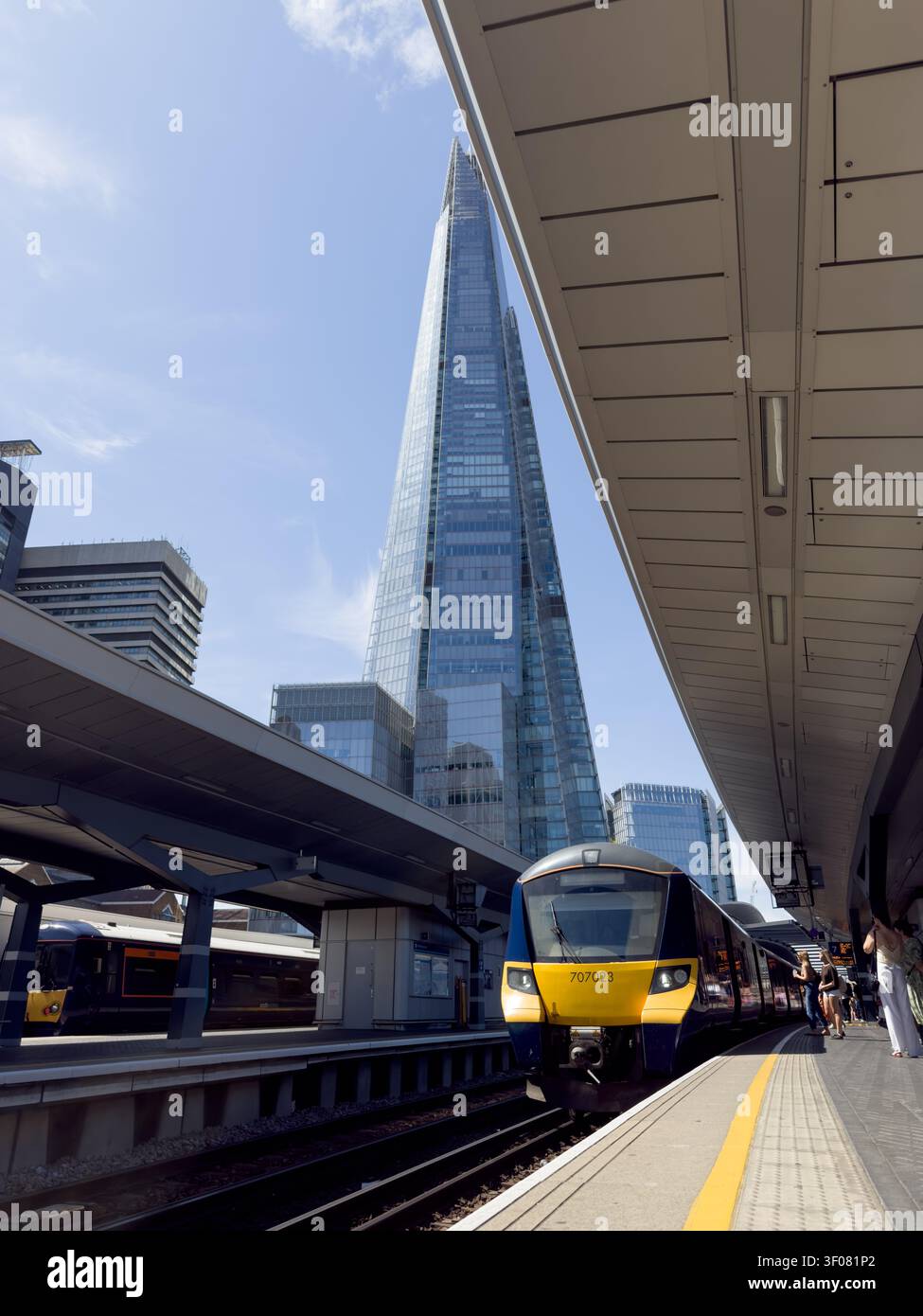 Un train Southeastern arrive sur le quai de la gare de London Bridge, avec la flèche en verre de The Shard se dressant en arrière-plan, Londres Banque D'Images