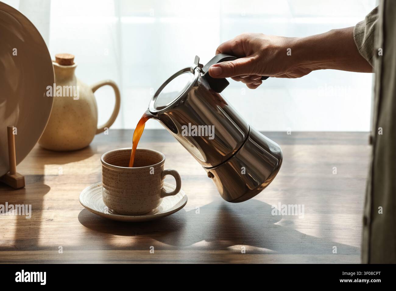 Verser le café du pot de moka dans la tasse en céramique Banque D'Images