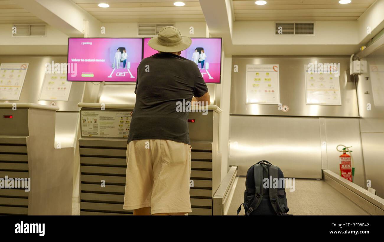 Homme faisant enregistrer ses bagages au comptoir de l'aéroport Banque D'Images
